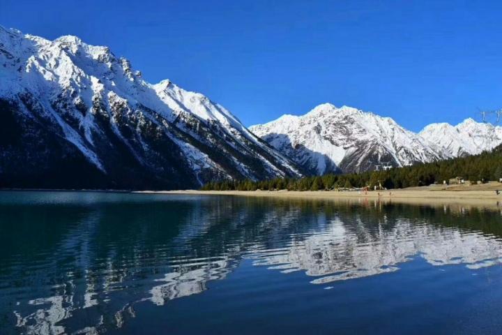 川藏线上藏东秘境然乌湖,三四月初春,然乌湖湖水清澈湛蓝,周围是白雪